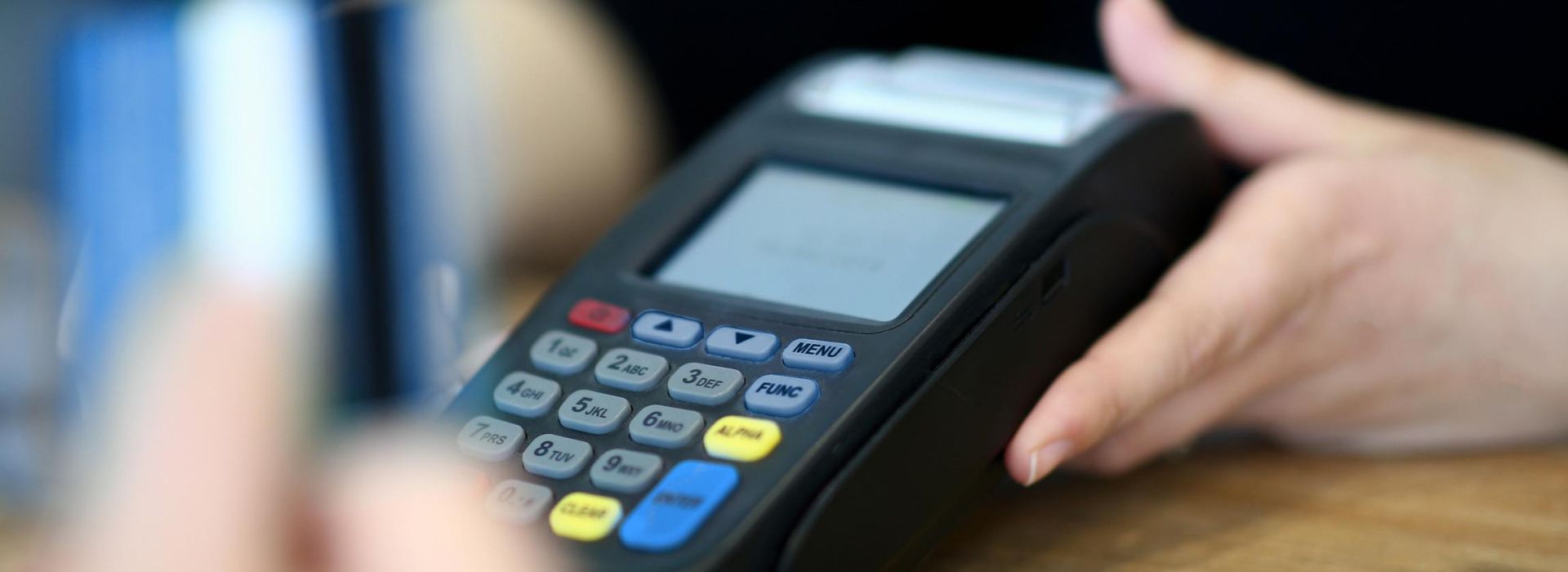 Eine Person hält ein EC-Cashgerät in den Händen.