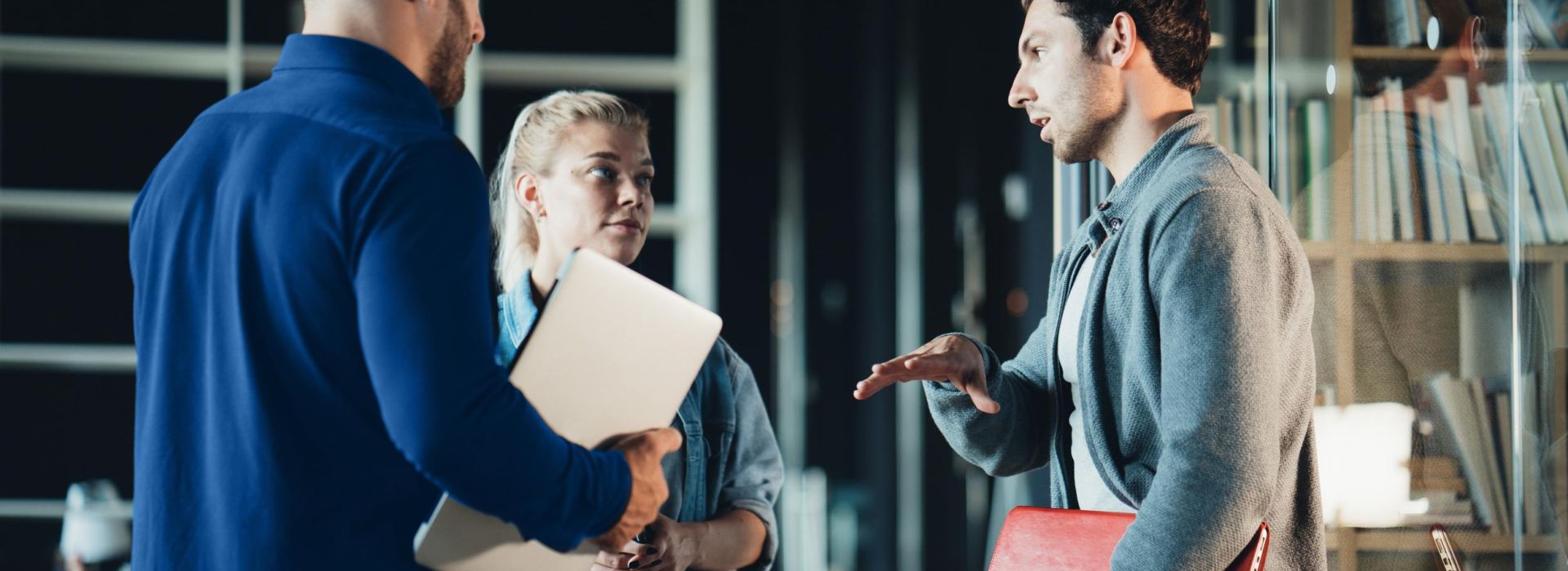 Ein Team aus zwei Männern und einer Frau im Gespräch.