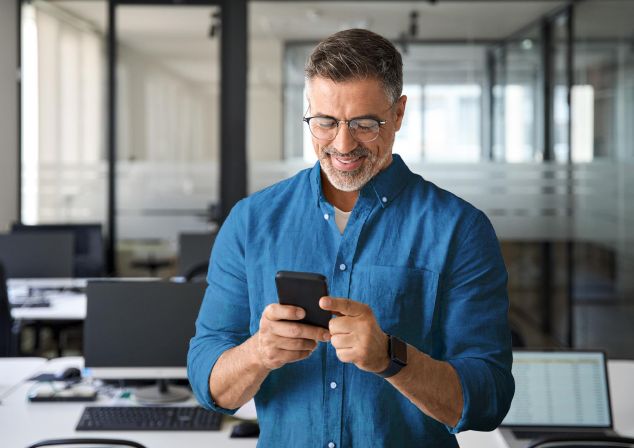 Ein Mann schaut auf ein Smartphone.